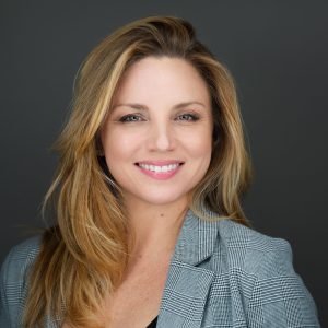 Kirstin Boncher, creative Boca Raton photographer, smiling in a grey blazer