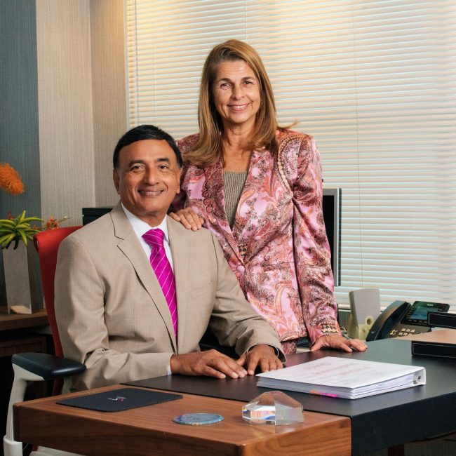 A husband-and-wife medical team standing together in a modern office.